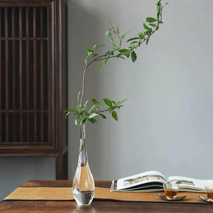 Modern flared glass vase filled with holiday-themed branches, styled on a mantel with candles for seasonal decor.