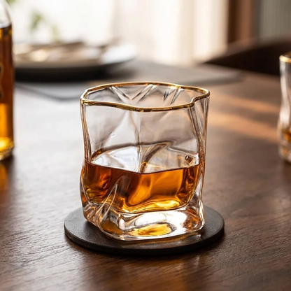 Glass of whiskey on a wooden table with a blurred background