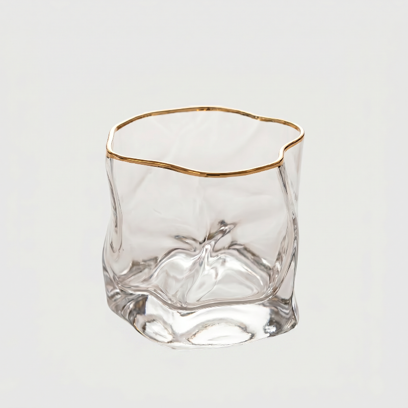 Clear glass with gold rim on a light gray background