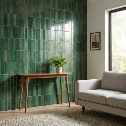 Forest green glossy subway tile accent wall in a living room with a wood console table and potted fern