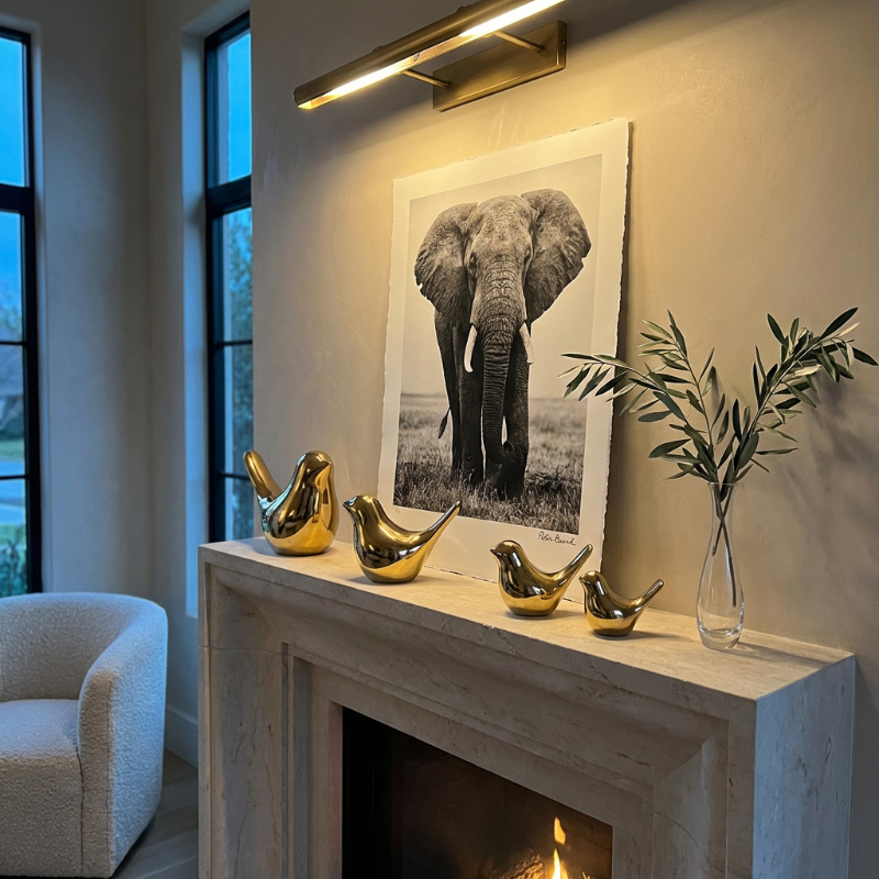 Gold bird sculptures styled on fireplace mantel beside framed artwork