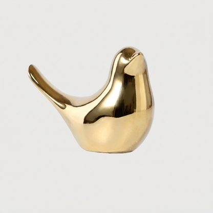 Gold bird sculpture on white background facing right