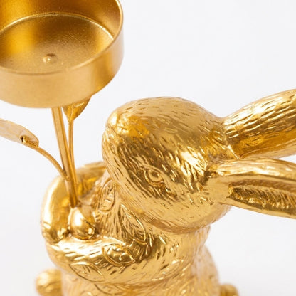 Close-up of gold rabbit candle holder with head turned, ears folded back