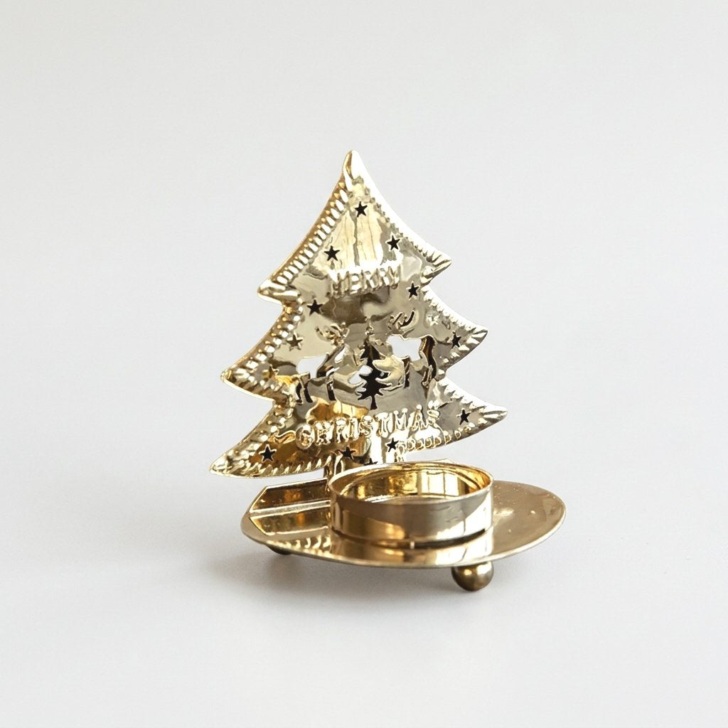 Gold-plated tree-shaped tealight candle holder with an unlit candle on a plain background