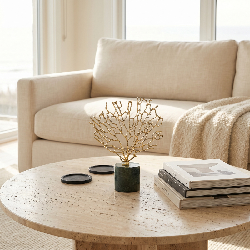 Gold coral sculpture in white vase on round coffee table