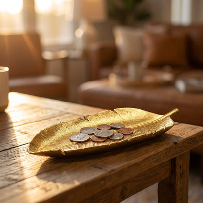 Gold leaf tray with coins on a rustic wood coffee table at sunset
