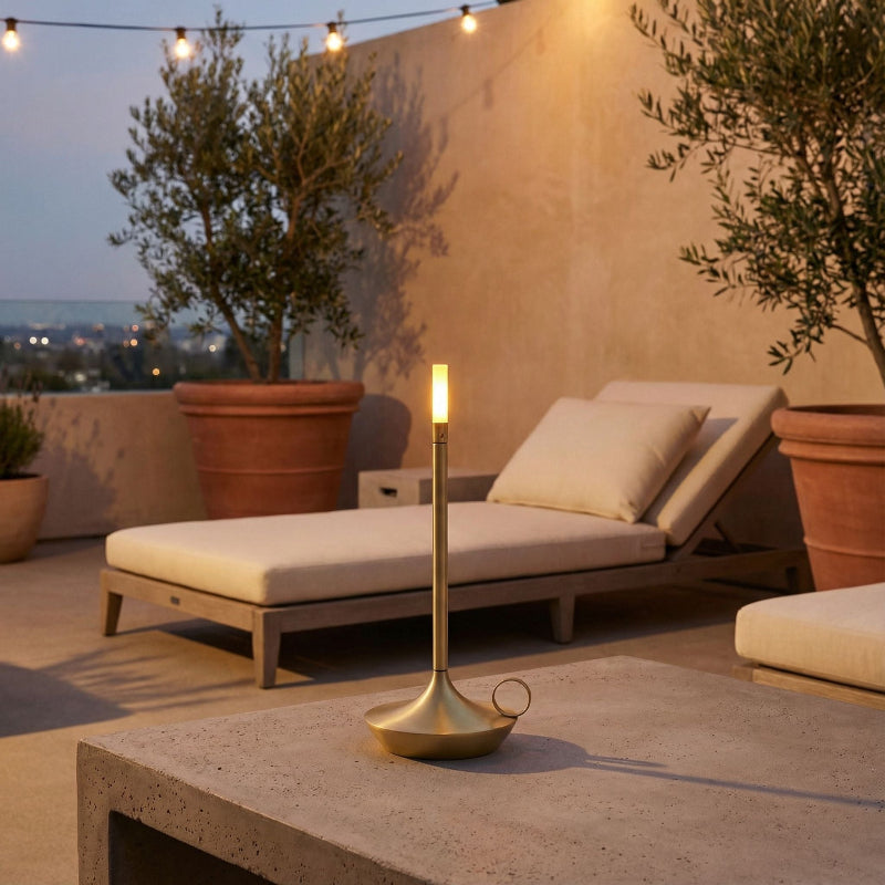 Outdoor patio with lounge chair, potted plants, and lit candle on a table.