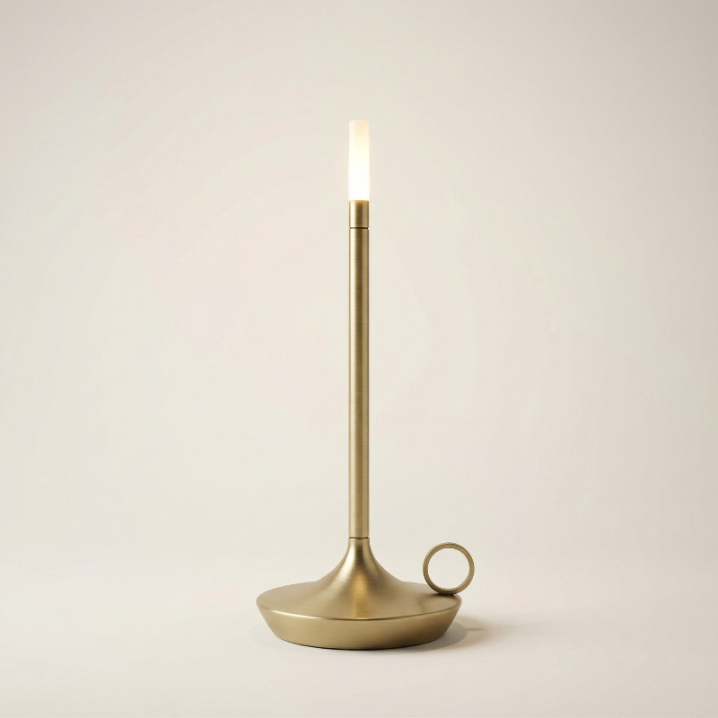 Brass candle holder with a lit candle on a beige background