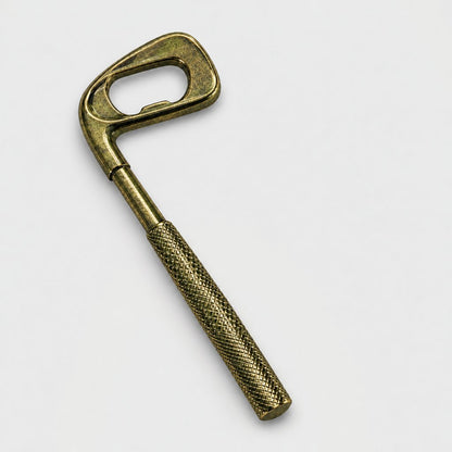 Bronze golf club shaped bottle opener on a plain light background