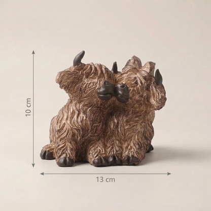 Bronze-colored bison figurine with dimensions on a beige background