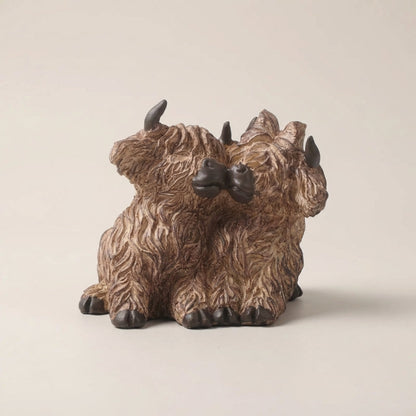 Bronze-colored triceratops dinosaur figurine on a beige background