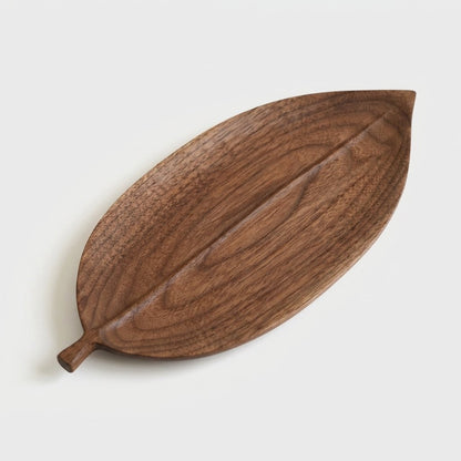 Large elliptical walnut leaf tray with a carved center vein on a light background