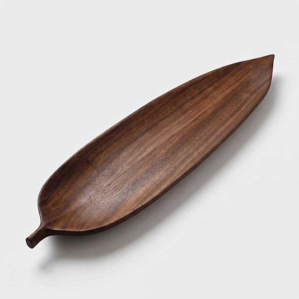 Lanceolate walnut leaf tray, long and narrow with a pointed tip, on a light background