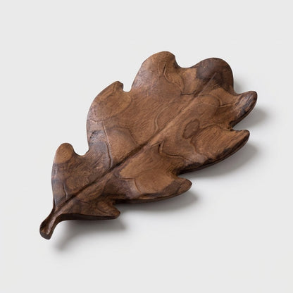 Small runcinate walnut leaf tray with deep lobes on a light background