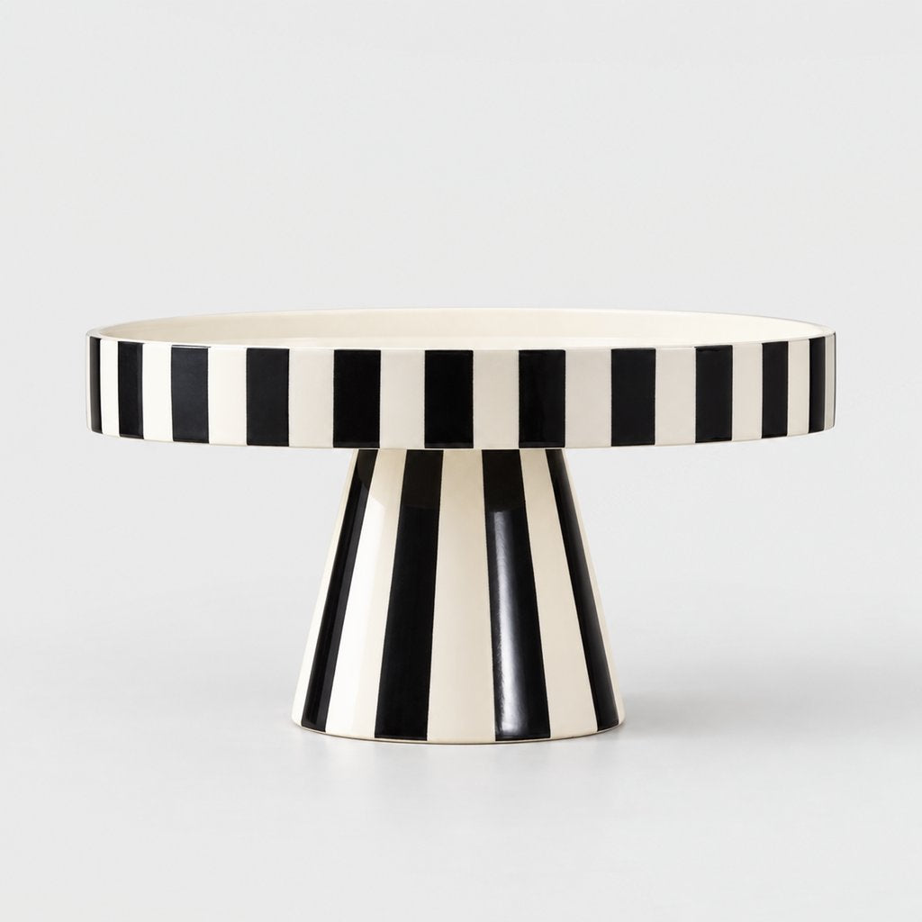Side view of a black and white striped pedestal tray on a plain light background