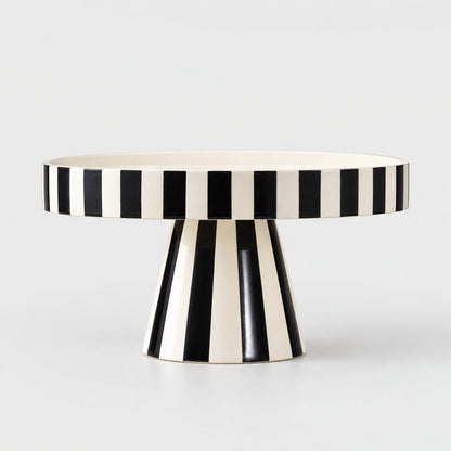 Side view of a black and white striped pedestal tray on a plain light background
