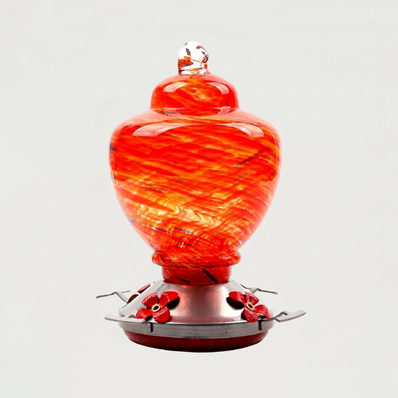 Red handblown glass hummingbird feeder on white background