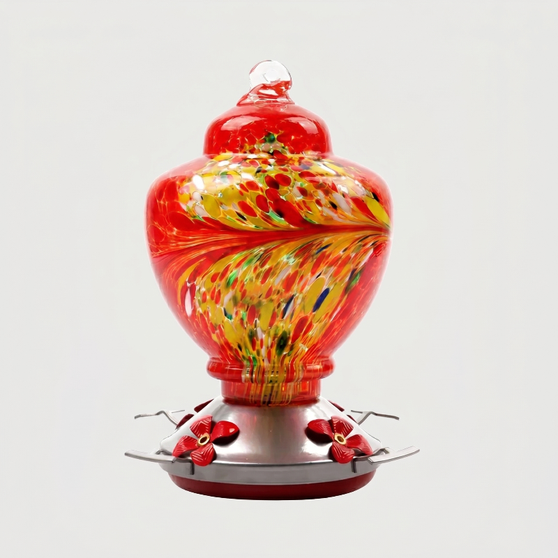 Red handblown glass hummingbird feeder on white background