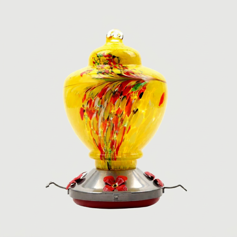 Yellow handblown glass hummingbird feeder on white background