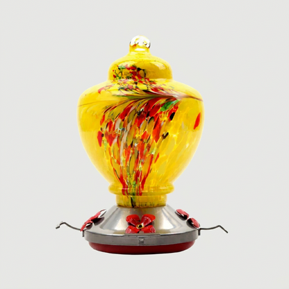 Yellow handblown glass hummingbird feeder on white background