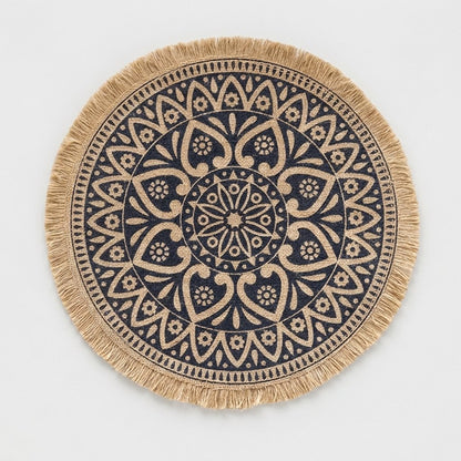 Round handwoven jute placemat with a navy floral mandala pattern and jute fringe edge on a light grey background