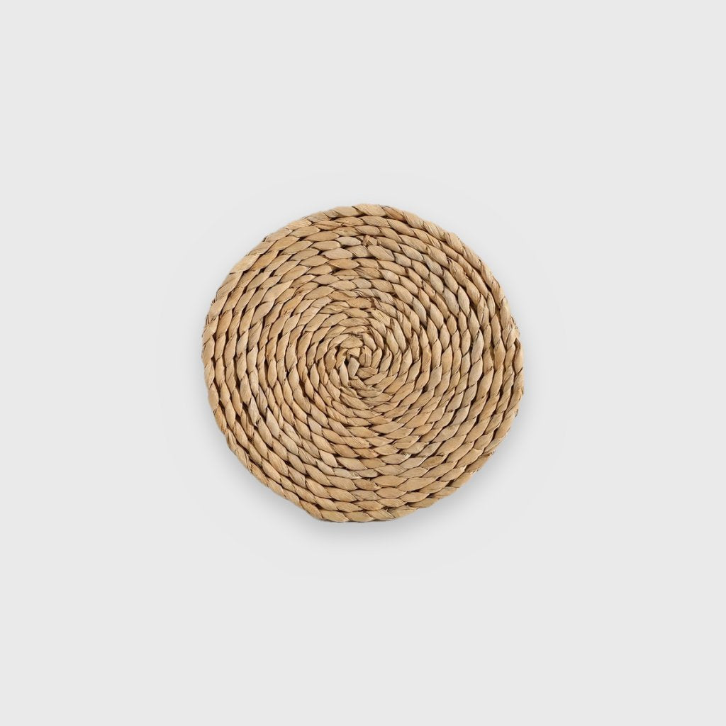 Single flat golden-tan coiled woven wall basket on a plain light gray background
