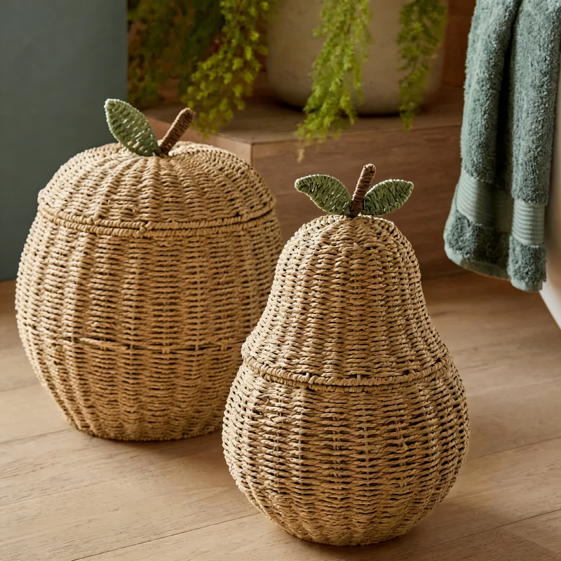 Apple-shaped rattan storage basket used for organization.