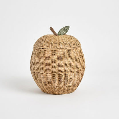 Apple-shaped woven rattan lidded basket with a brown stem and a green leaf on a light background