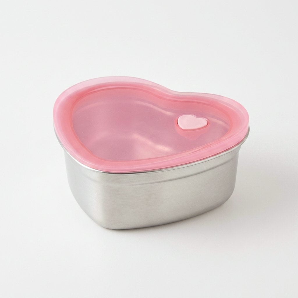 Close-up three-quarter view of the Heart-Shaped Stainless Steel Food Container with pink silicone lid
