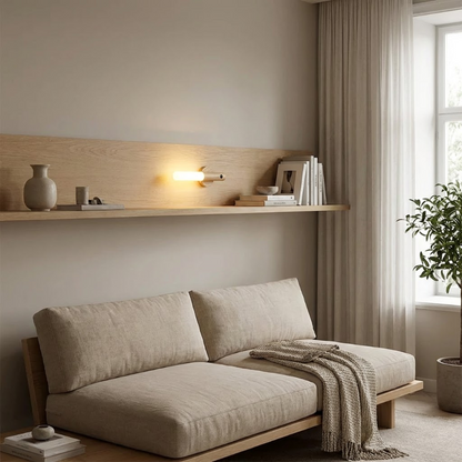 Beige sofa in a living room with a shelf and window in the background