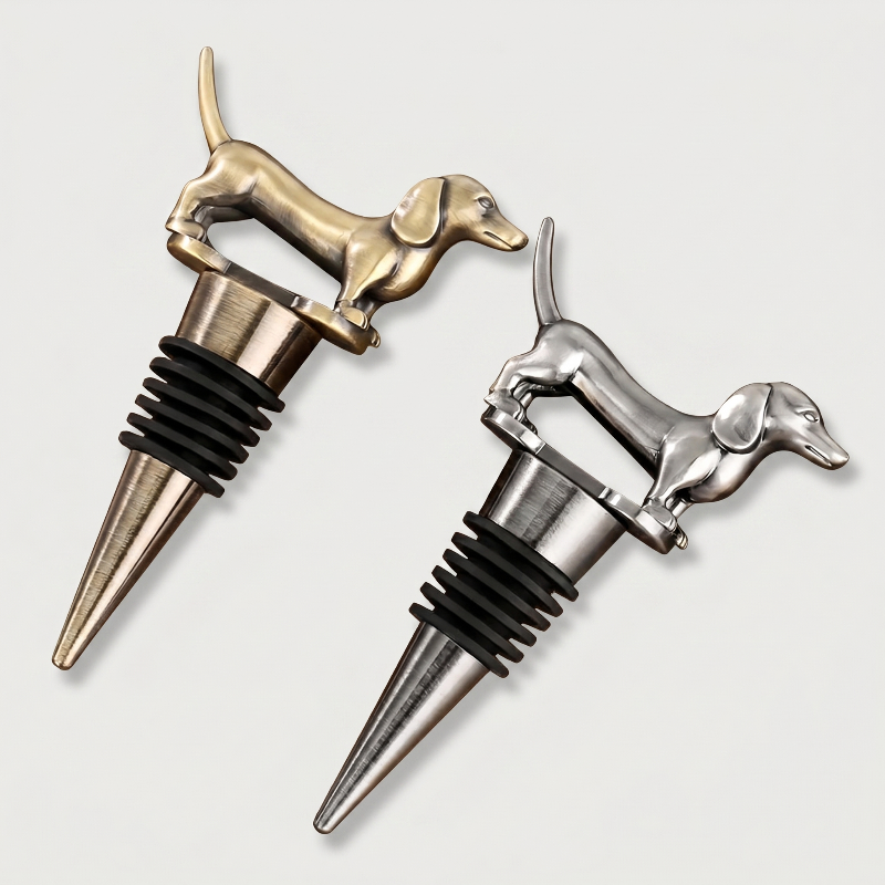 Two dachshund shaped bottle stoppers, one gold and one silver, on a light gray background.
