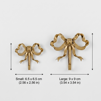 Small and large gold bow-shaped wall hooks side by side on a plain background with measurements marked: small 2.6 by 2.6 inches, large 3.5 by 3.5 inches