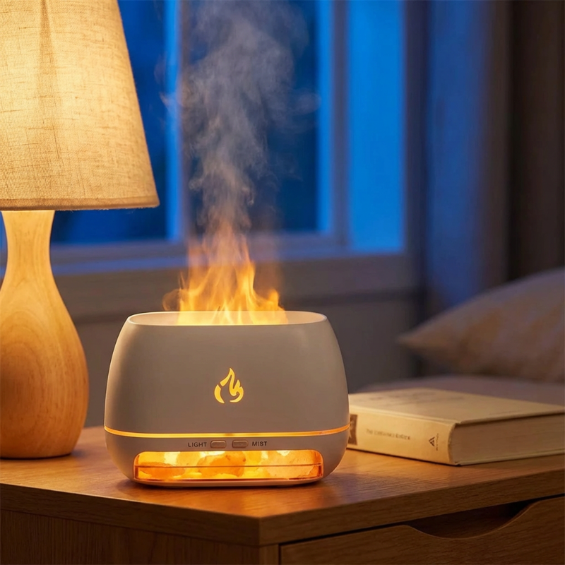Faux flame diffuser on a table with a lamp and book in the background