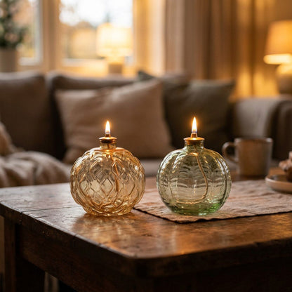 Lit Gold Ornament and Green Ornament glass oil lamps on a rustic wood coffee table in a cozy living room