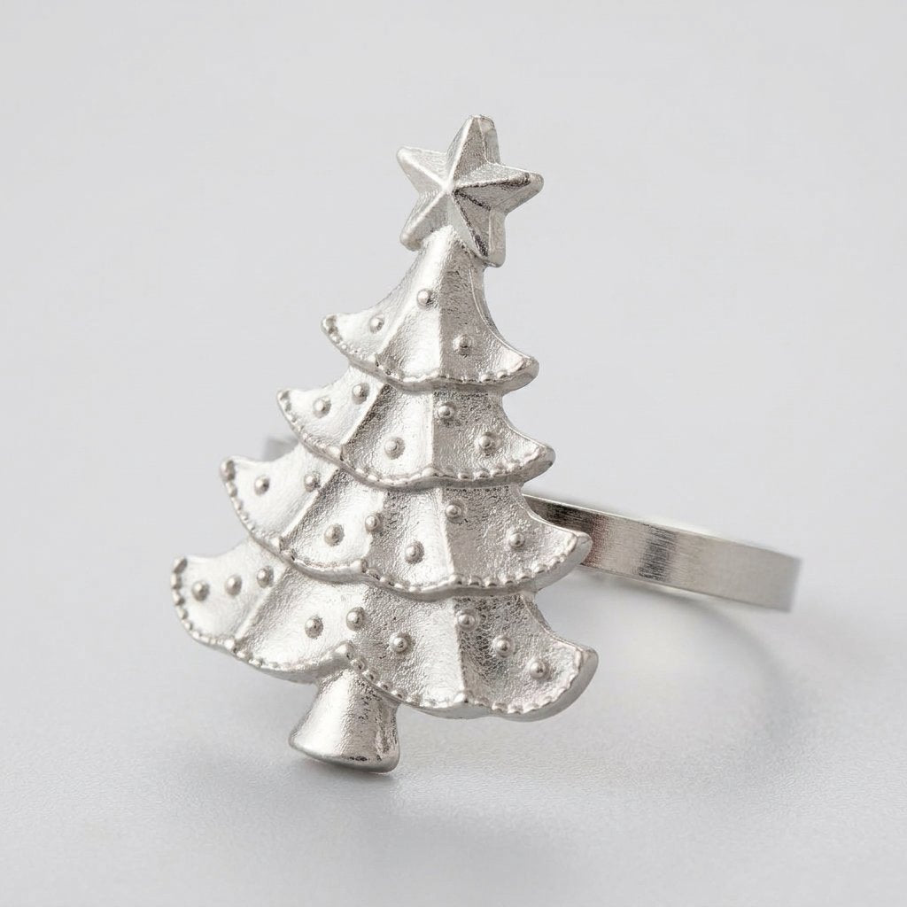 Close-up of a silver Christmas tree napkin ring with a star and beaded tiers on a light gray background
