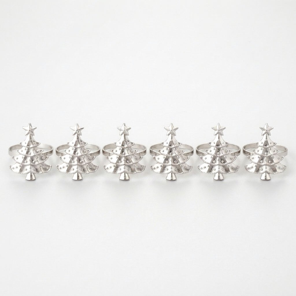 Six silver Christmas tree napkin rings in a row on a white background