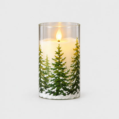 Medium flameless candle printed with a snowy pine tree and a glowing flame on a plain light background