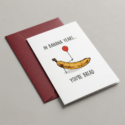 Greeting card with banana and bread illustration and humorous text on a gray background