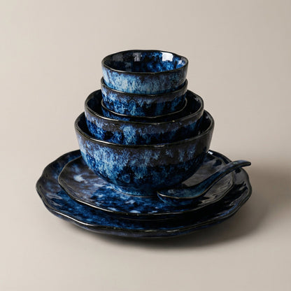 Set of blue ceramic bowls and plates on a beige background