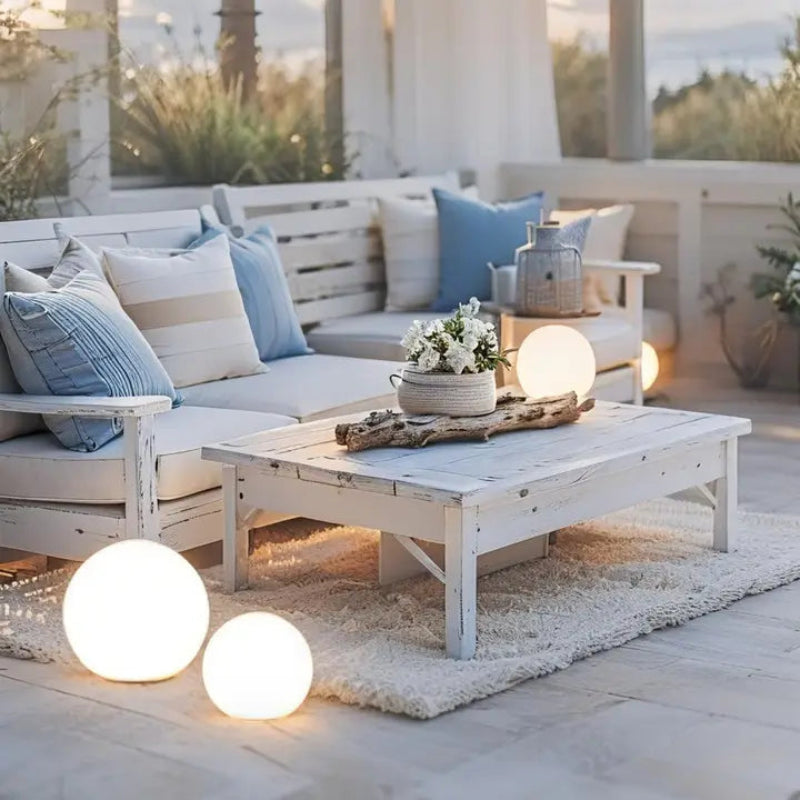 LED garden ball lights on outdoor sofa with candles