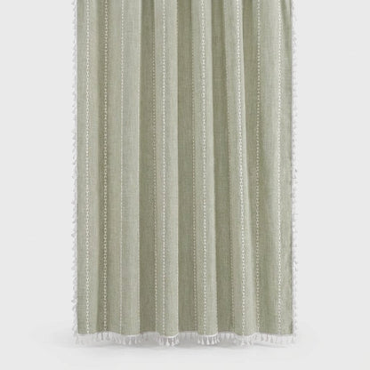 Sage green linen shower curtain with thin white stitched vertical stripes and white tassels on a light grey background