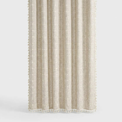 Light oatmeal windowpane linen shower curtain with a faint cream grid and cream tassels along the hem and sides on a light grey background