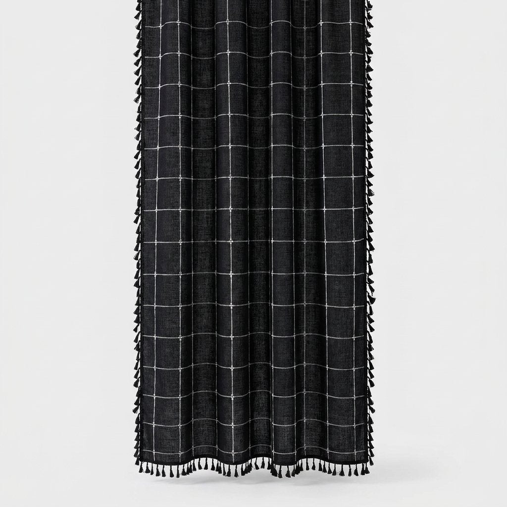 Black windowpane linen shower curtain with a thin white grid and black tassels along the sides and hem on a light background