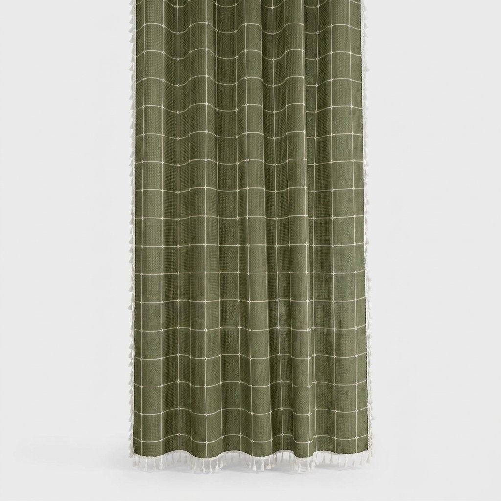 Olive green windowpane linen shower curtain with a cream grid and white tassels on the hem and sides on a light grey background