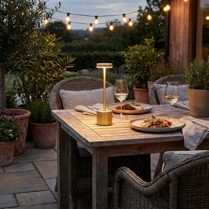 Luca touch table lamp in gold on outdoor dining table