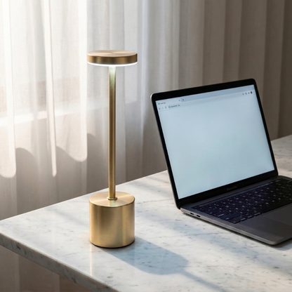 Luca touch table lamp in gold on desk beside tablet