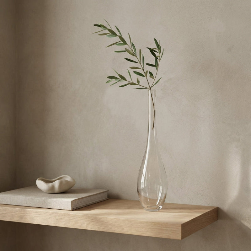 Lucia hand-blown clear glass vase with olive stem on wooden shelf