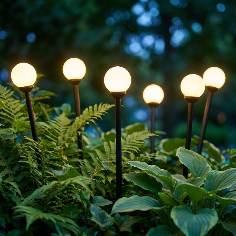 Glowing garden lights embedded in green foliage