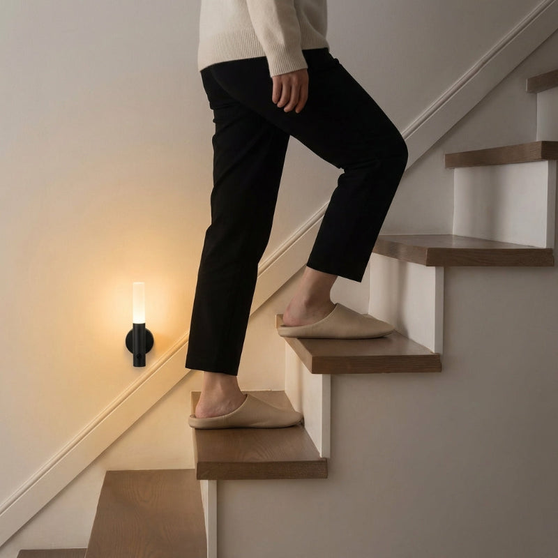 Person descending a staircase wearing black pants and beige shoes.