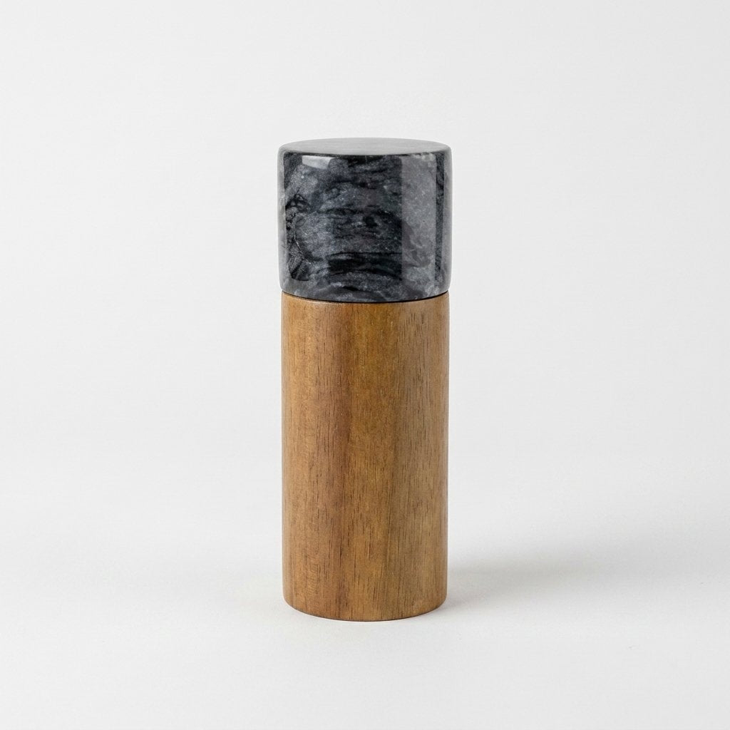 Black marble-topped acacia wood hidden grinder mill on a light studio background